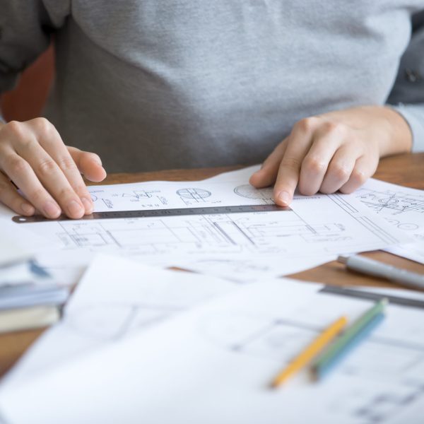 Female hands, working at the desk with a ruler and a drawing. Education concept photo, close-up